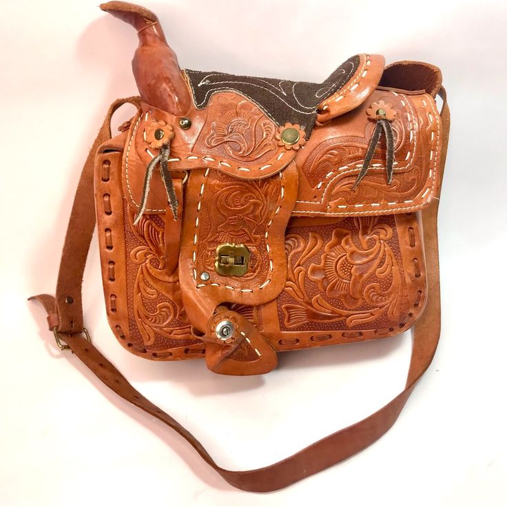 Own This Cool One-Of-A-Kind Hand-Tooled Saddle Top Bag. Turn-Lock Closure. The Inside Is Unlined At The Bottom, The Top Has Soft Sherpa Wool Fur Lining Just Like A Saddle. It's Fully Open And Roomy. Adjustable Strap. Gently Used Preowned Vintage Condition. The Stirrup On The Back Has Minor Damage. Leather Stain Drips On Bottom/Side (See Pics). Non-Smoking Home. Approximate Measurements Laying Flat: Tbd Like This Item But Not The Price? Make An Offer, Let's See What We Can Do. Bundle Items From My Closet And Get A Discount. Pay One Shipping Charge If The Total Weight Is Under 5 Pounds. New To Poshmark Or You Found Me On Google? Use My Referral Code “Classicdaisy” When You Sign Up For Luxury Leather Saddle Bag For Errands, Hand Tooled Crossbody Satchel For Travel, Brown Saddle Tote Bag For Errands, Brown Tote Saddle Bag For Errands, Leather Saddle Bag With Leather Handles, Leather Saddle Tote Bag With Leather Backing, Hand Tooled Satchel Saddle Bag For Travel, Leather Saddle Bag With Leather Backing, Leather Handle Saddle Bag