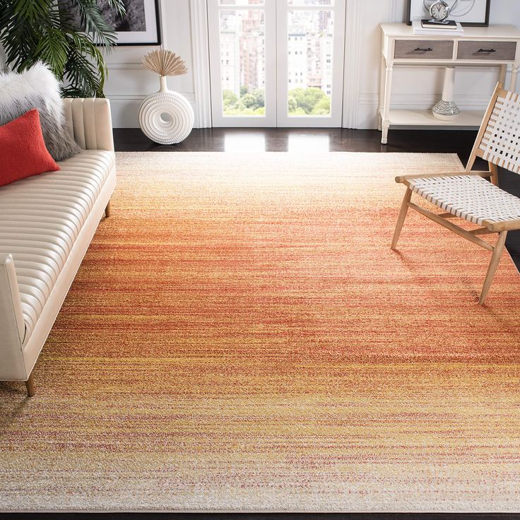 a living room filled with furniture and a rug on top of a hard wood floor