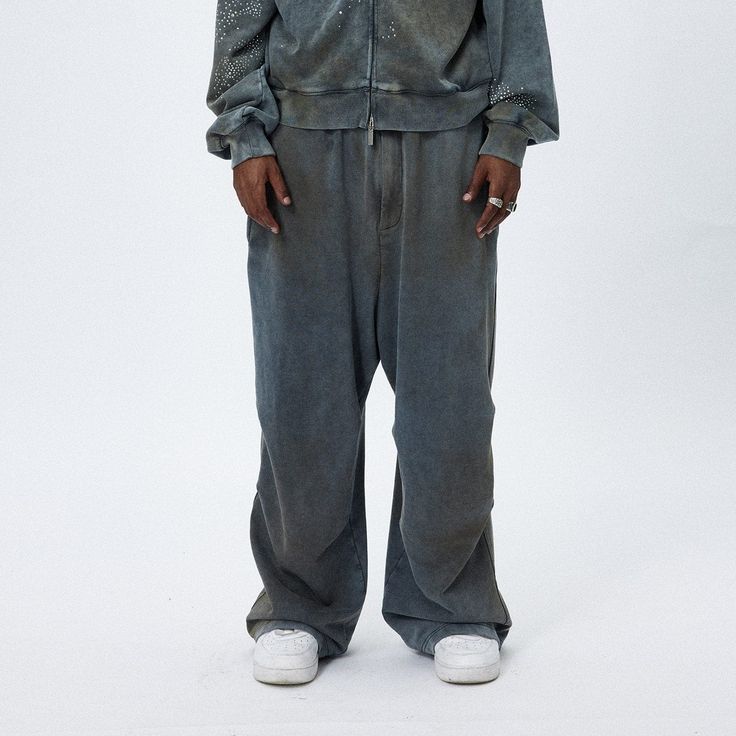 The Distressed Crinkled Baggy Sweatpants are a unique fusion of relaxed style and textured design. These sweatpants showcase a stonewashed, distressed look, creating a vintage and worn-in appeal that is both fashionable and comfortable. A distinctive feature of these pants is the double crinkled design strategically placed on both the inner and outer sides of the legs, adding an interesting visual and tactile element to the garment. The oversized silhouette of the pants offers a contemporary, re Faded Oversized Urban Bottoms, Faded Baggy Grunge Pants, Oversized Faded Urban Bottoms, Grunge Style Washed Wide Leg Pants, Acid Wash Wide Leg Pants For Streetwear, Grunge Wide Leg Washed Pants, Grunge Style Wide Leg Washed Pants, Acid Wash Relaxed Fit Wide Leg Bottoms, Wide Leg Washed Pants For Streetwear