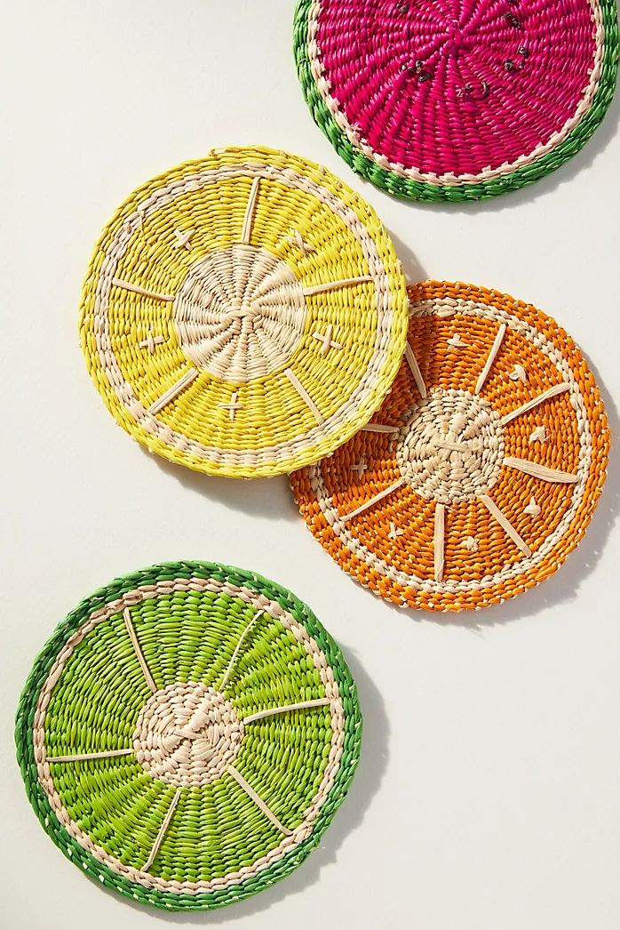 three woven coasters with different colors and designs on the top one has an orange, yellow, and green design