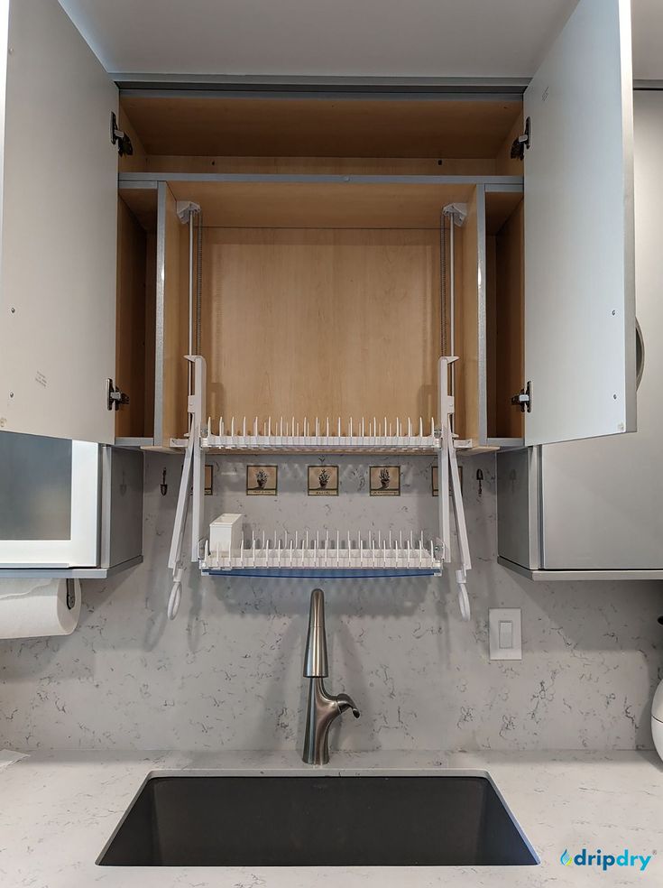 a kitchen sink with an open cabinet above it