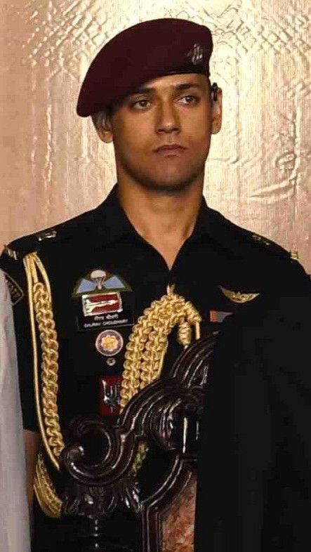 a man in uniform standing next to a wall