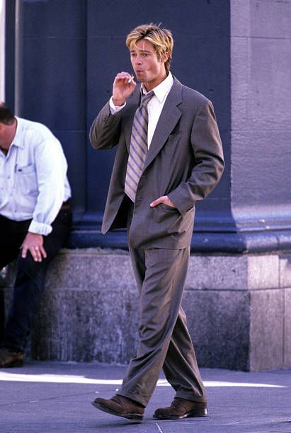 a man in a suit and tie walking down the street