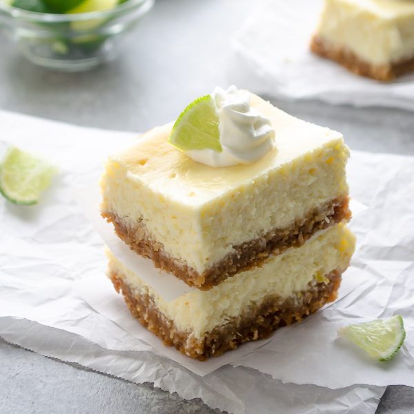 three pieces of cake sitting on top of paper next to a bowl of limes