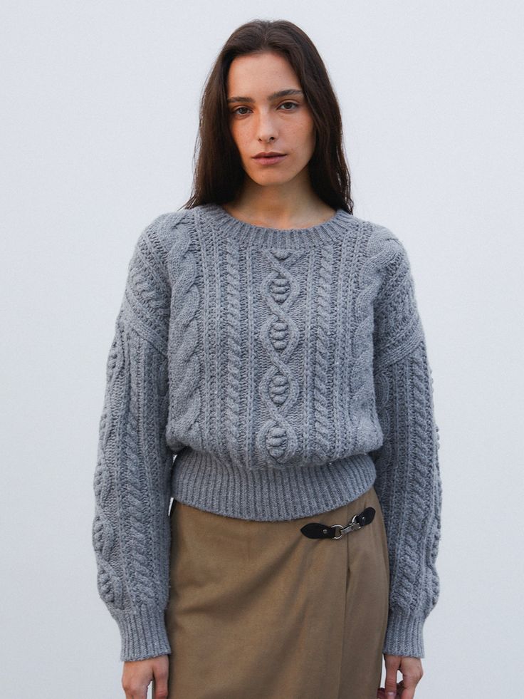 Editor's NotesThe sweater is a chunky knit style crafted with a high wool content, ensuring a soft touch. It features wide sleeve cuffs and a voluminous fit for a comfortable feel. The intricate cable pattern and knitting are distinctive characteristics that add texture and visual interest to the garment.- Composed of wool for a soft and cozy feel.- Chunky style knit sweater provides a relaxed and comfortable fit.- Detailed with a delicate cable pattern for a classic aesthetic.Measurements(in.)Size: One Size (XS-M)- Length: 19.69- Shoulder: 22.83- Bust: 21.26- Chest: 14.57- Sleeve: 19.29- Armhole: 7.87*Model info: Height 5.70866 Bust 32.6772  Waist 23.622 Hips 35.4331Composition & Care- 30% Wool, 70% Others- Dry CleaningDesigner- by THE WAVE Winter Cashmere Chunky Knit Sweater, Winter Chunky Knit Cashmere Sweater, Fall Chunky Knit Merino Wool Sweater, Oversized Merino Wool Cable Knit Sweater, Chunky Knit Wool Sweater For Fall, Cable Pattern, Grey Knit Sweater, The Wave, Cable Knit Sweater