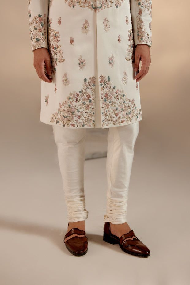 Opaline Sherwani | Jatin Malik Presenting our ivory placement hand-embroidered sherwani set, a true masterpiece. Crafted with meticulous attention to detail, this sherwani features a captivating embroidery design. The foundation is adorned with colorful resham threads, intricately woven with golden zari and dabka accents. The combination of these elements creates a stunning visual effect, showcasing the richness of craftsmanship and tradition. Perfect for those who appreciate refined elegance and intricate artistry, this sherwani set is bound to leave a lasting impression. Included in purchase: Sherwani, Kurta, Churidar Product Specification Color: Ivory Fabric: Linen silk Occasion: Engagement, Wedding, Bridal, Reception Style: Sherwani, Kurta, Churidar Care: Dry Clean Work: Hand Embroider Ivory Sherwani, Jatin Malik, Embroidered Sherwani, Mens Kurta Designs, Rohit Bal, Indian Wedding Outfits, Indian Fashion Designers, Ivory Pearl, Pernia Pop Up Shop