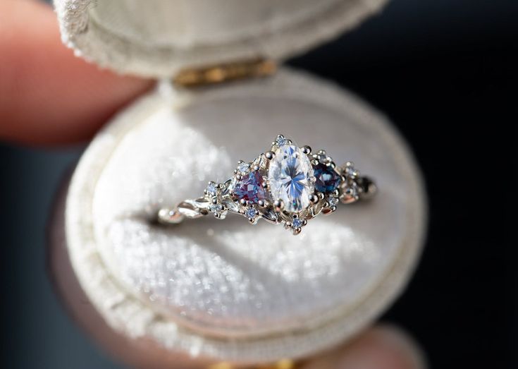 someone is holding an engagement ring in their hand, with the inside of it open