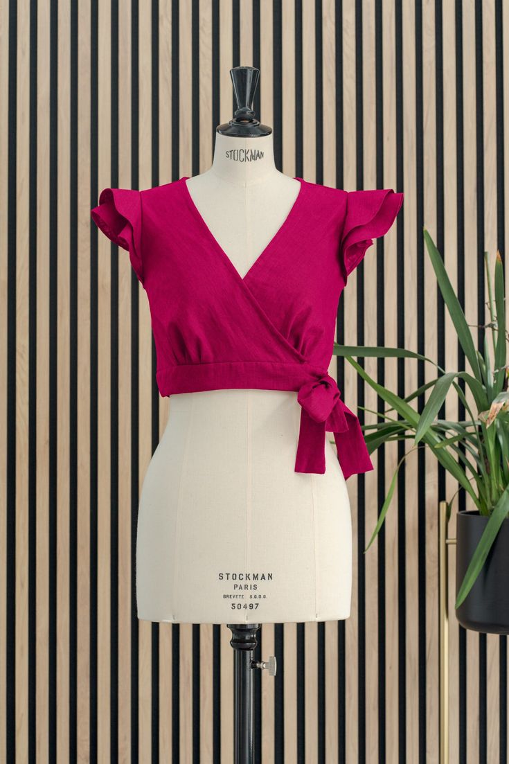 Discover the vibrant charm of our Cherry V-Neck Crop Top, a treasure for those who cherish artisanal beauty and sustainable fashion. 🍒 This handcrafted piece shines in a vivid cherry hue, with a deep V-neckline that offers both a touch of allure and a dash of sophistication. The bow tie closure provides a sweet and adjustable detail, while the ruffle sleeves dance with each movement, creating an air of playful elegance. ✂️ Superior Craftsmanship: Precision stitching and attention to detail ensu V-neck Tie Back Crop Top For Party, Summer V-neck Tie Back Crop Top, Elegant Cotton Crop Top, Chic V-neck Crop Top With Tie Back, Chic Cropped Tie Waist Crop Top, Chic Fitted Crop Top With Tie Waist, Chic Cropped Crop Top With Tie Waist, Elegant Summer Blouse With Tie Waist, Summer Wrap Top With Tie Back