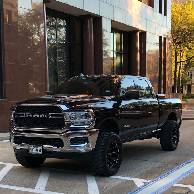 a large black truck parked in front of a building