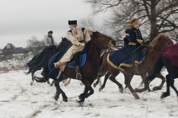 three people are riding horses in the snow