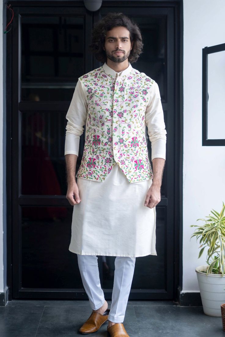 Off white bundi with floral embroidered motifs. Paired with kurta and pant.
Component: 3
Pattern: Embroidered
Type Of Work: Floral
Neckline: Band
Sleeve Type: Three Quarter
Fabric: Semi Raw Silk
Color: White
Other Details: 
Floral embroidery
Occasion: Destination Wedding - Aza Fashions Kurta Pants, Sleeveless Kurta, Mehendi Outfit, Haldi Outfits, Mehendi Outfits, Kurta Set For Men, Elegant Jacket, Nehru Jacket, Ethnic Looks