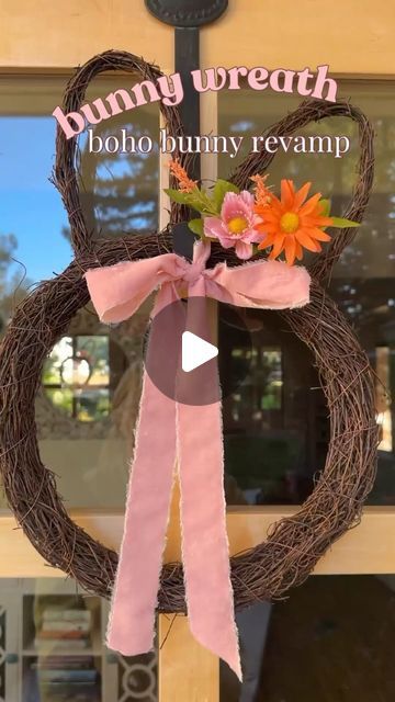 the front door of a store with a wreath and ribbon hanging from it's side