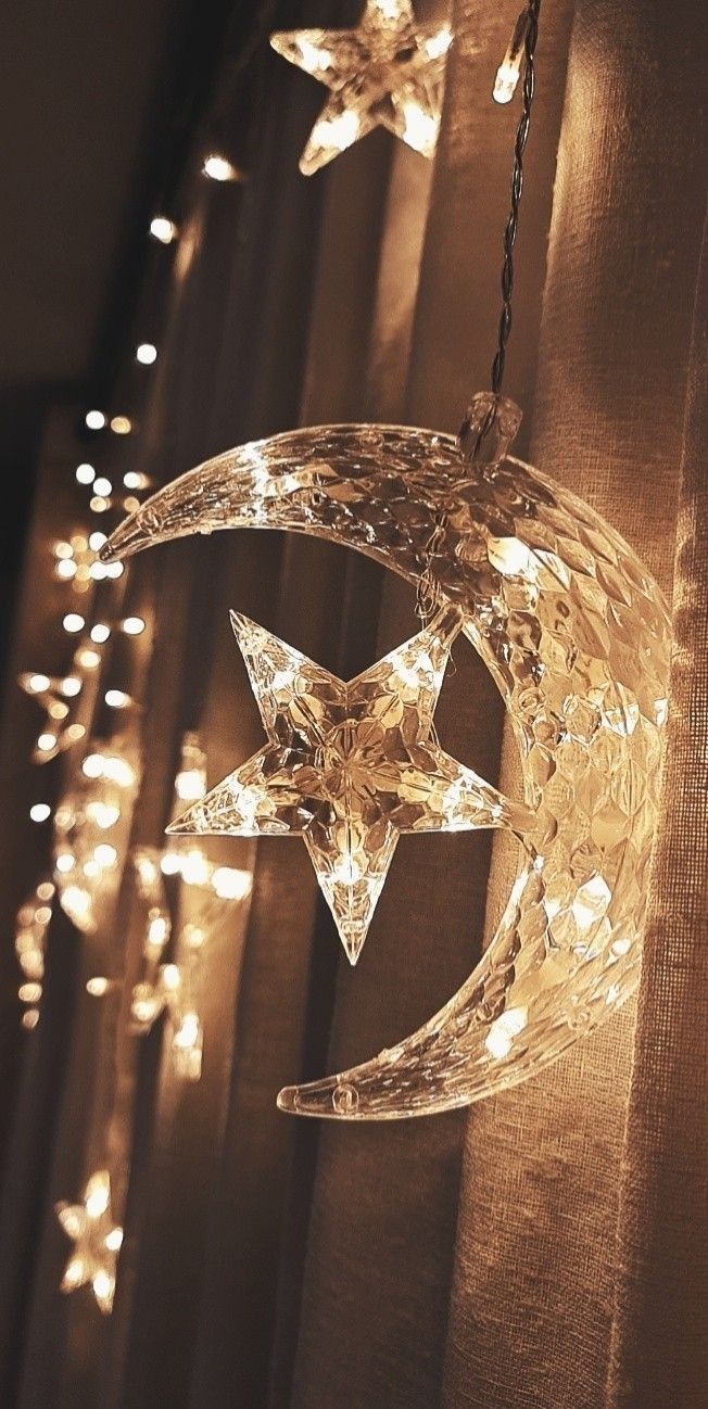 a star and moon light hanging from a curtain