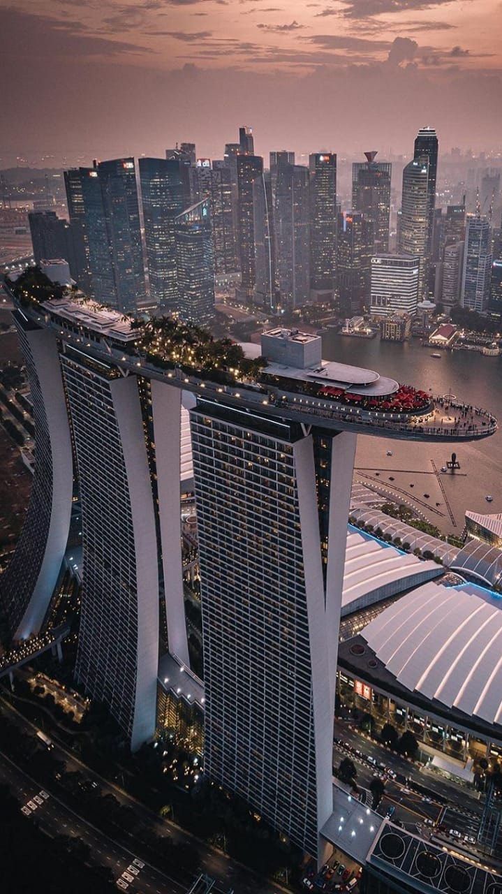 an aerial view of the marina bay and its surrounding skyscrapers at dusk in singapore