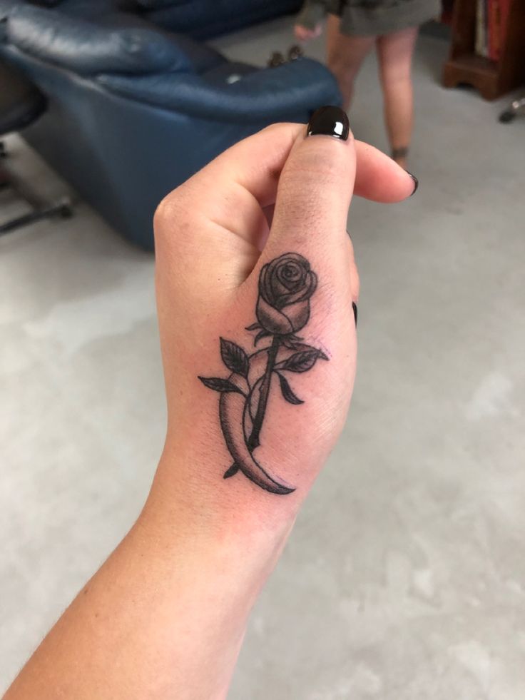 a person with a rose tattoo on their hand