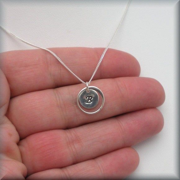 "A lovely sterling frame encircles a small initial charm. Personalized and simple - the perfect neckace to stand alone or layer, as you wish. Each initial is handstamped and then slightly darkened to stand out on the sterling disc. The pendant measures slightly larger than 1/4\" round (9 mm). Sterling silver curb chain. All other components are sterling silver. Jewelry is packaged in a cotton lined box for gift-giving. See more Bonny Jewelry at http://bonnyjewelry.etsy.com If this is a gift and Silver Circle Sterling Silver Charm Necklace, Silver Circle Charm Necklace In Sterling Silver, Silver Sterling Silver Circle Charm Necklace, Silver Charm Necklaces With Initials, Sterling Silver Charm Necklaces, Adjustable Sterling Silver Round Charm Necklace, Adjustable Round Sterling Silver Charm Necklaces, Dainty Circle Charm Necklace In Sterling Silver, Sterling Silver Charm Necklace Gift