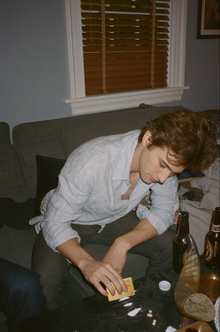 a man sitting on top of a couch next to bottles