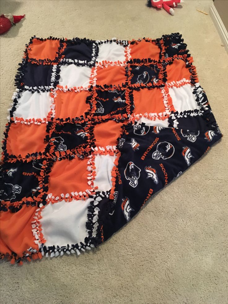 an orange and black blanket laying on the floor