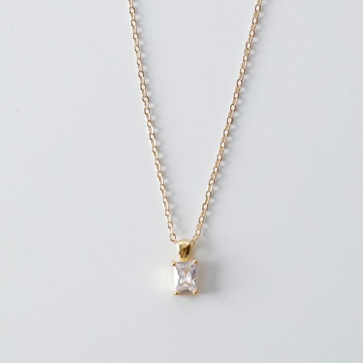 This is a dainty necklace with a small emerald cut CZ pendant. Perfect for everyday wear. Necklace Metal: 14K Gold filled Necklace Size: 16 in Pendant Metal : 18K Gold FilledPendant Size: 13 mm x 5 mm Pendant Stone: Cubic Zirconia Please allow up to 48 hours for us to prepare your order and 3-5 business days for shipping itself. Thank you darling! Elegant Gold Birthstone Necklace With Cubic Zirconia, Dainty Gold Emerald Necklace For Formal Occasions, Classic Gold Emerald Necklace With Diamond Cut, Elegant Gold Emerald Necklace With Diamond Cut, Elegant Gold Birthstone Necklace With 17 Jewels, Elegant Gold Plated Birthstone Necklace, Elegant Everyday Emerald Necklace In Gold, Elegant Gold Cubic Zirconia Birthstone Necklace, Elegant Gold Emerald Necklace For Everyday