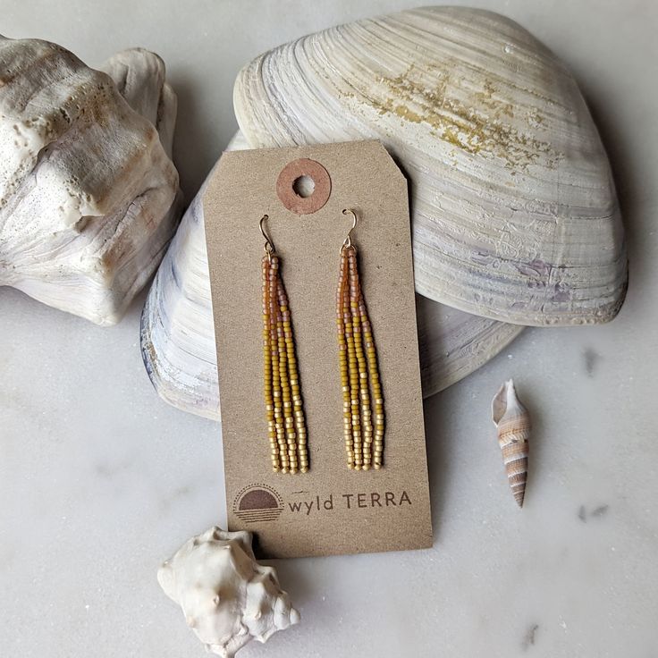 The most dreamy sun kissed inspired color combination! These earrings have the most gorgeous peachy and lavish gold feel to them. Inspired by those sunny days at the beach when the sun is reflecting off the water like diamonds. The same beaded fringe earrings you love in a shorter style. Perfect for those days when you are more active, out exploring nature! These earrings are very lightweight. A more playful, free flowing option to studs. Featuring 4 strands of hand woven matte and frosted glass Orange Drop Earrings For The Beach, Orange Drop Earrings For Beach, Adjustable Gold Beaded Earrings For Beach, Orange Dangle Jewelry For Beach, Gold Dangle Tassel Earrings For The Beach, Summer Orange Earrings With Tiny Beads, Gold Beaded Earrings For Summer, Yellow Tassel Earrings For Beach, Gold Dangle Tassel Earrings For Summer