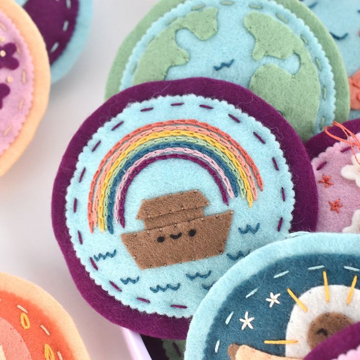 several felt badges with different designs and colors are shown in this close up shot,