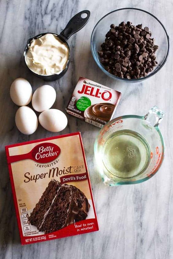 ingredients for chocolate cake sitting on a marble counter top next to an egg, milk, and yogurt