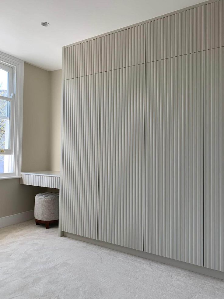 an empty room with white walls and carpeted flooring, along with a large sliding door