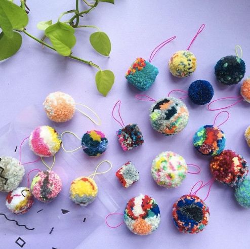 there are many different colored balls on the table next to each other and one is hanging from a string