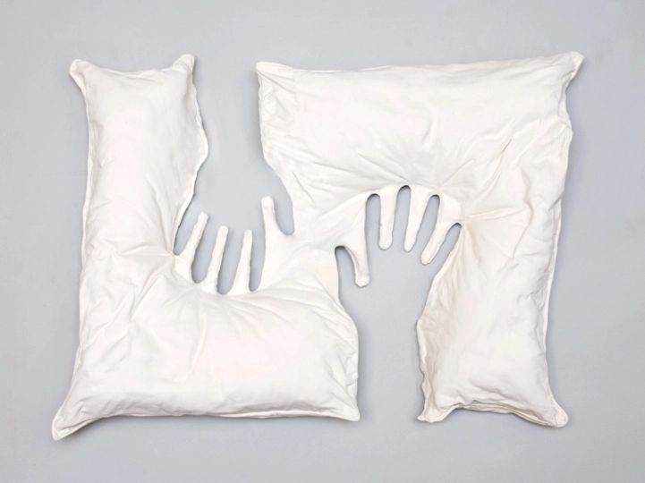 two pillows and one pillow that has been made to look like hands