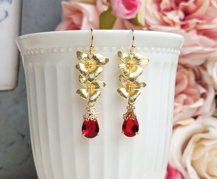 Gorgeous earrings feature gold orchid cascading flowers and sparkle red teardrop glass accented with flower lace.  On gold plated brass ear wires.   Earring length: 1.75 inches Drop size: 1.5 inches Purchase over $40 enjoys free shipping! Coupon code 'freeshipping1'. Free Gift Wrapping on request - All items that are gift wrapped come in with a kraft box with raffia string and blank writing card.  Please leave a note if you need it upon ordering. Red Gold Plated Drop Earrings, Elegant Red 14k Gold Filled Earrings, Red Filigree Drop Earrings, Formal Red Flower-shaped Earrings, Earring Bridal, Elegant Red 14k Gold-filled Earrings, Orchid Earrings, Gold Orchid, Cascading Flowers