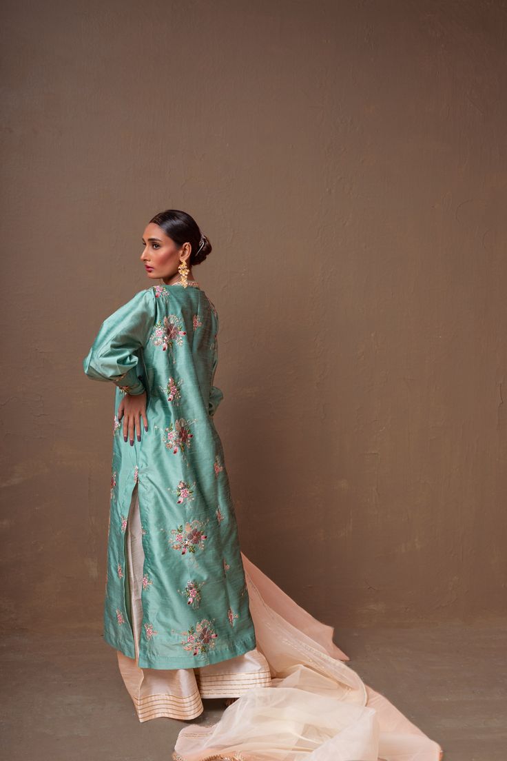 A ferozi colored, raw silk shirt with floral hand-embroidery and a net, organza pearl white dupatta and raw silk ajar pants.3-Piece SuitReady to wear Spring Silk Embroidered Anarkali Set, Spring Embroidered Silk Anarkali Set, Designer Silk Sharara With Floral Embroidery, Silk Floor-length Palazzo Set With Floral Embroidery, Silk Sharara With Floral Embroidery For Eid, Silk Anarkali Set With Zari Work For Spring, Eid Silk Sharara With Floral Embroidery, Spring Raw Silk Palazzo Set With Straight Kurta, Spring Palazzo Set In Raw Silk With Straight Kurta