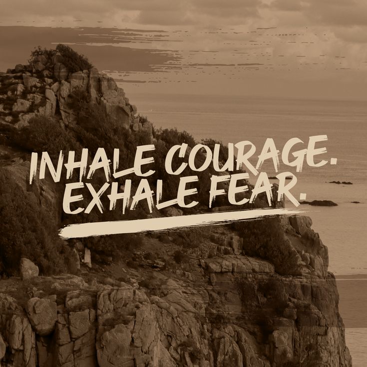 a sign that reads inhale courage exhale fear on the side of a cliff