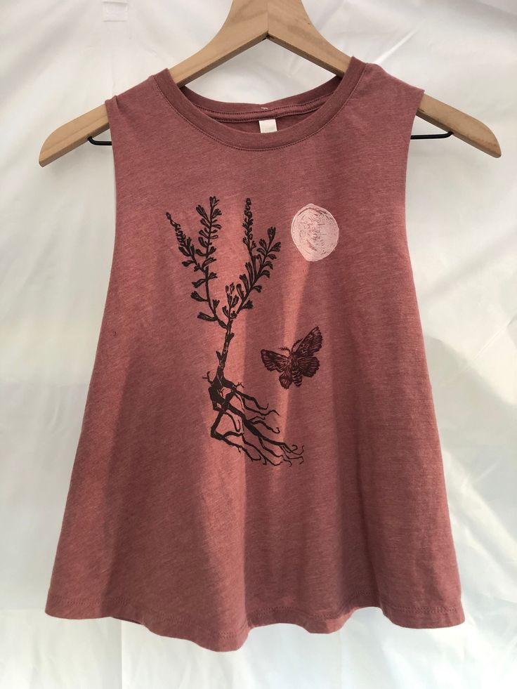 Please note that this is a pre-order. For more info scroll down to the bottom of this description** This tank starts with a super-soft Bella + Canvas women's cropped racerback tank in heather mauve. It is made with 52% cotton and 48% polyester. It fits small, but loose and airy on the sides.  I love Bella +  Canvas because they are committed to doing things a better way whenever possible. Learn more here: https://blog.bellacanvas.com/fast-fashion-done-right/ I print these beautiful blank canvases with my original art, in this case, an American Lappet moth flitting about through the strongly rooted sagebrush, under a bright full moon.  Here in the high desert of Nevada, sagebrush and cottonwood act as keystone plant species, and have helped wild beings and humans make this place home. The m Spring Fitted Graphic Print Muscle Tee, Spring Fitted Muscle Tee With Graphic Print, Spring Cotton Racerback Muscle Tee, Spring Soft-washed Cropped Crop Top, Spring Season Soft-washed Cropped Top, Spring Soft-washed Crew Neck Tank Top, Spring Crew Neck Soft-washed Tank Top, Spring Cotton Crop Top For Yoga, Spring Soft-washed Muscle Tee