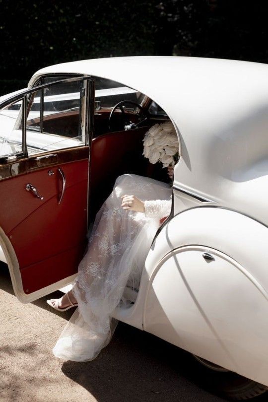 a woman sitting in the back of a white car