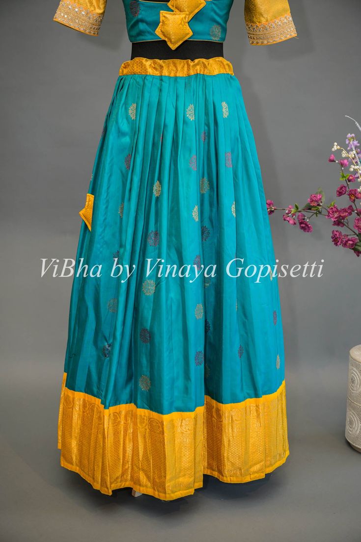 Teal Blue and Yellow Gadwal Silk Lehenga With Embroidered Hemline Of The Sleeves. This teal blue and yellow Gadwal silk lehenga features exquisite embroidery along the hemline of the sleeves for a stunning look. Crafted from a lightweight yet durable fabric, this lehenga is a sophisticated choice for your formal wardrobe.. Blue And Yellow Indian Outfit, Yellow Silk Lehenga With Intricate Embroidery, Yellow Embroidered Art Silk Lehenga, Yellow Dola Silk Floor-length Lehenga, Yellow And Blue Lehenga, Lehenga Blouse, Embroidered Dupatta, Blouse Material, Silk Lehenga