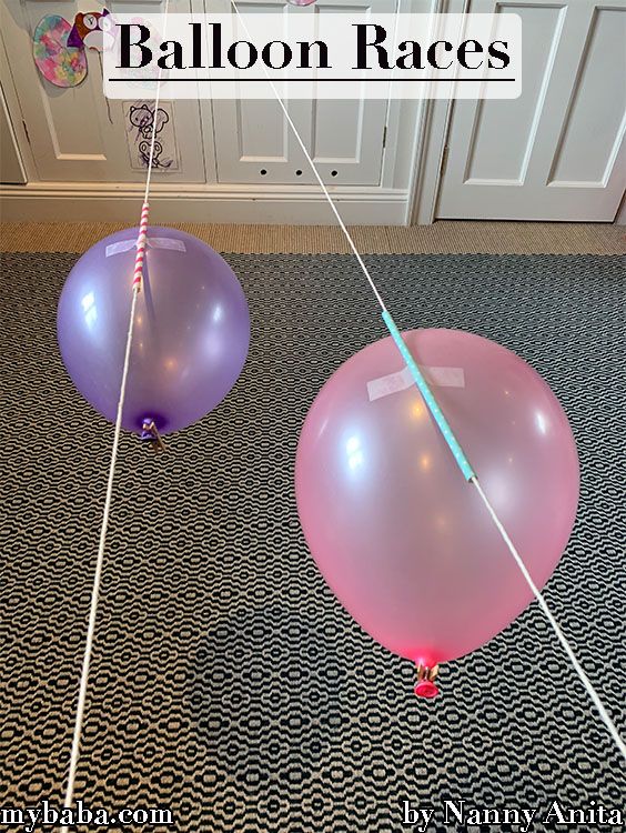 two balloons that are on the ground with string attached to them and one balloon is in the air