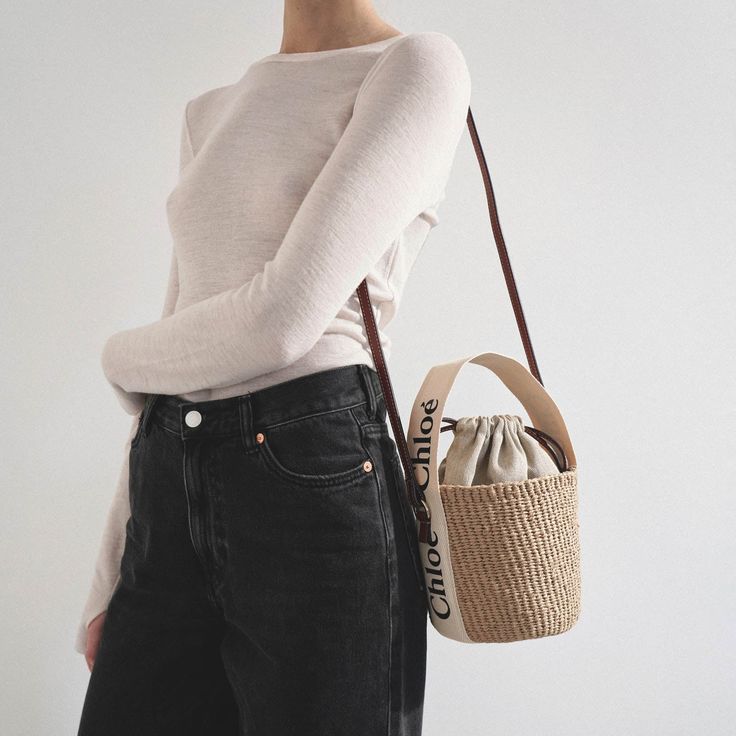 Brown raffia bucket bag with white detailing from Chloé. The Woody tote bag is handwoven from partly upcycled materials by independent craftswomen in Kenya. It features a drawstring fastening and a long leather strap for shoulder and crossbody wear. It is complete with an embroidered Chloé logo for graphic contrast and signature touch.Measurements: L17 x H16 x W16cmMade in Italy Beige Woven Bucket Bag With Round Handle, Beige Handwoven Top Handle Bucket Bag, Chic White Basket Straw Bag, Chic Handwoven Natural Bucket Bag, Chic Natural Handwoven Bucket Bag, Eco-friendly Beige Bucket Bag For Shopping, Chic Handwoven Straw Bucket Bag, Casual Neutral Bucket Bag Tote, Eco-friendly Woven Bucket Bag With Top Handle