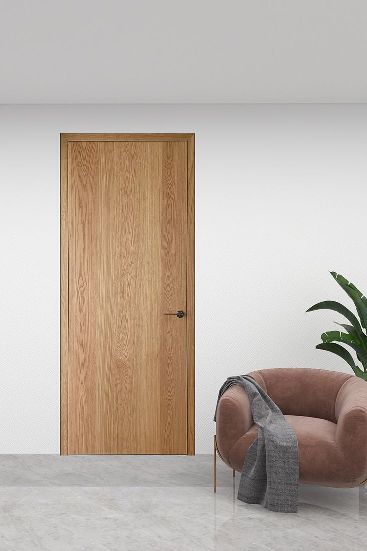 an empty room with a chair, potted plant and wooden door