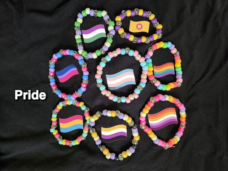 several colorful bracelets with beads on a black background and the words pride written across them