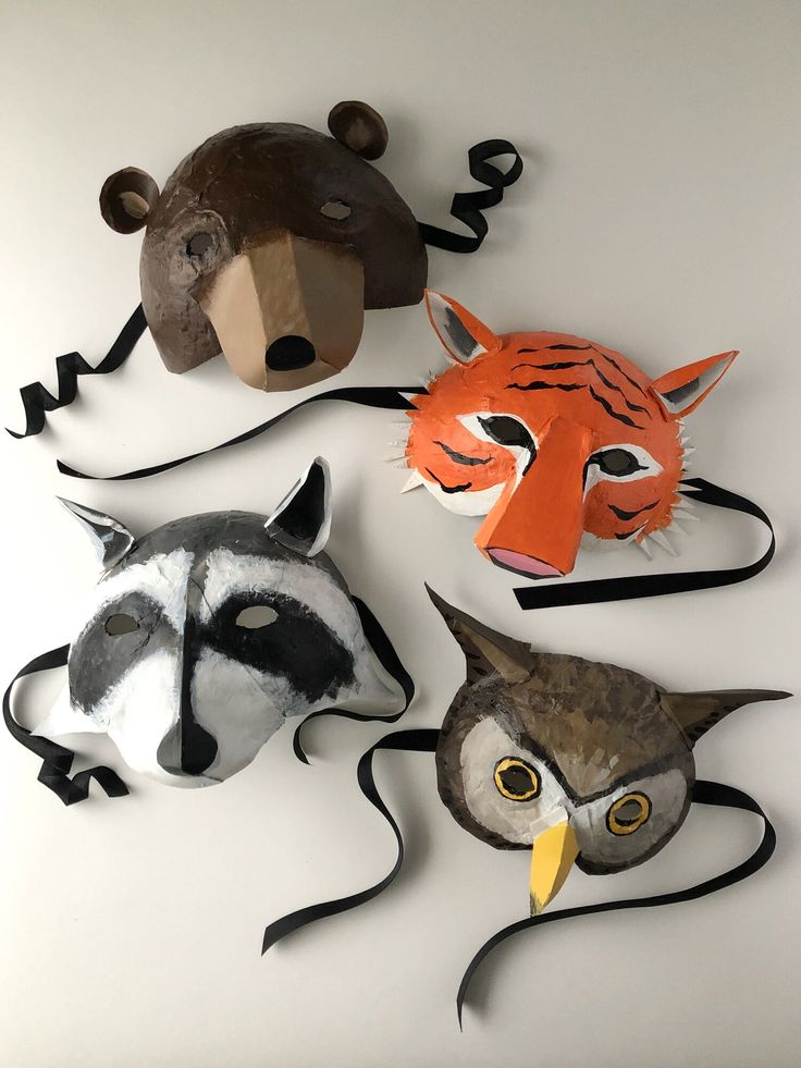 four animal masks are arranged on a white surface