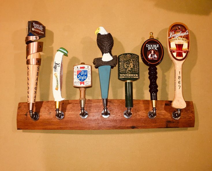 there are many different types of beer taps on this shelf, including one with an eagle