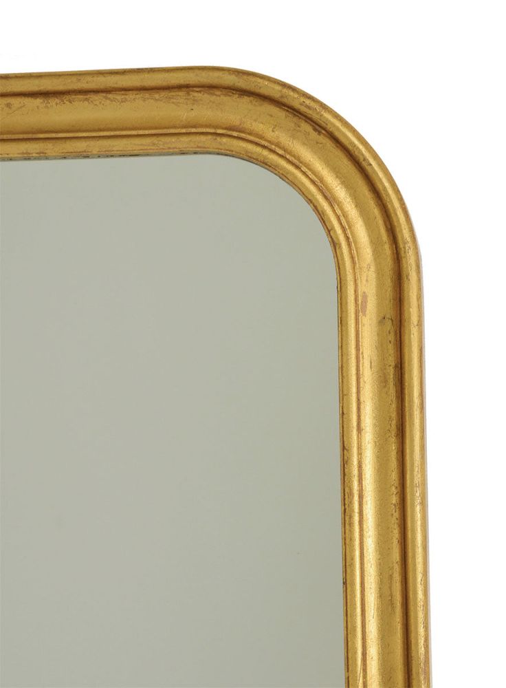 a gold framed mirror on a white wall