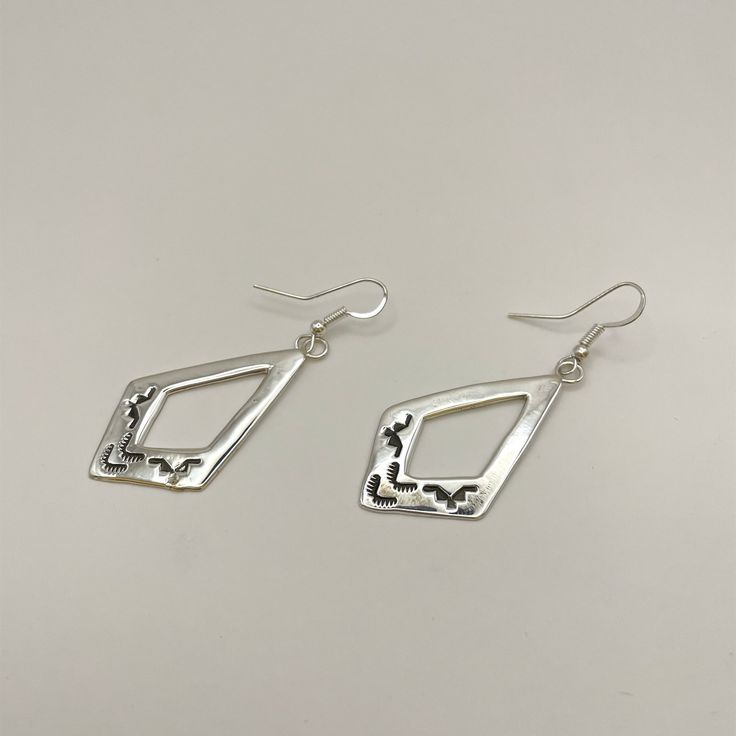 Stamped sterling silver dangle earrings featuring elegant French hook wires. Meticulously handcrafted by Navajo artist Pauline Nelson, these earrings showcase traditional artistry with a modern touch. Perfect for adding a unique, southwestern charm to your jewelry collection. Measurements: 2.4" x 0.9" (including wire)Weight: 0.26oz (7.43g)Material: Sterling silver (silver925) Ideal for both casual and formal wear, these earrings make a timeless addition to any wardrobe. Bohemian Jewelry With French Hook For Jewelry Making, Artisan Dangle Teardrop Earrings With Ear Wire, Artisan Teardrop Dangle Earrings With Ear Wire, Silver Dangle Hoop Earrings With French Hook, Bohemian Pierced Teardrop Earrings In Sterling Silver, Bohemian Dangle Jewelry With French Hook, Bohemian Sterling Silver Drop Earrings, Nickel Free Silver Southwestern Earrings, Artisan Sterling Silver Nickel-free Teardrop Earrings