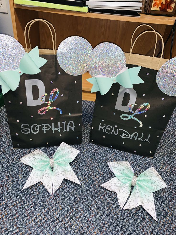 three bags with minnie mouse ears and name on them, sitting on the floor next to each other