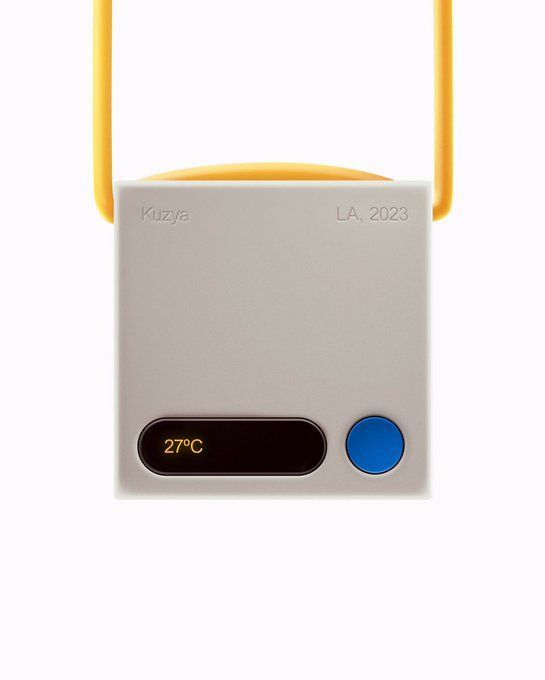 a white and yellow device with blue buttons on the front, sitting against a white background