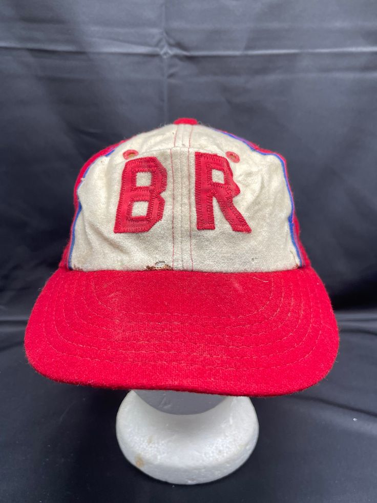 Vintage 1950's Felt Little League Baseball Hat Step up to the plate with this vintage 1950's felt Little League baseball hat. With a classic cap style, this red hat is perfect for any sports enthusiast. The hat comes in size S and is a great accessory for any vintage lover. Its unique design and charming appeal make it a great addition to any collection. Vintage Baseball Cap For Baseball Season, Retro Red Hats For Baseball Season, Red Retro Hats For Baseball Season, Red Retro Hat For Baseball Season, Vintage Red Six-panel Baseball Cap, Vintage Baseball Cap With Curved Brim, Retro Red Fitted Hat For Baseball Season, Red Retro Fitted Hat For Baseball Season, Vintage Snapback Hat For Baseball Season With Curved Brim