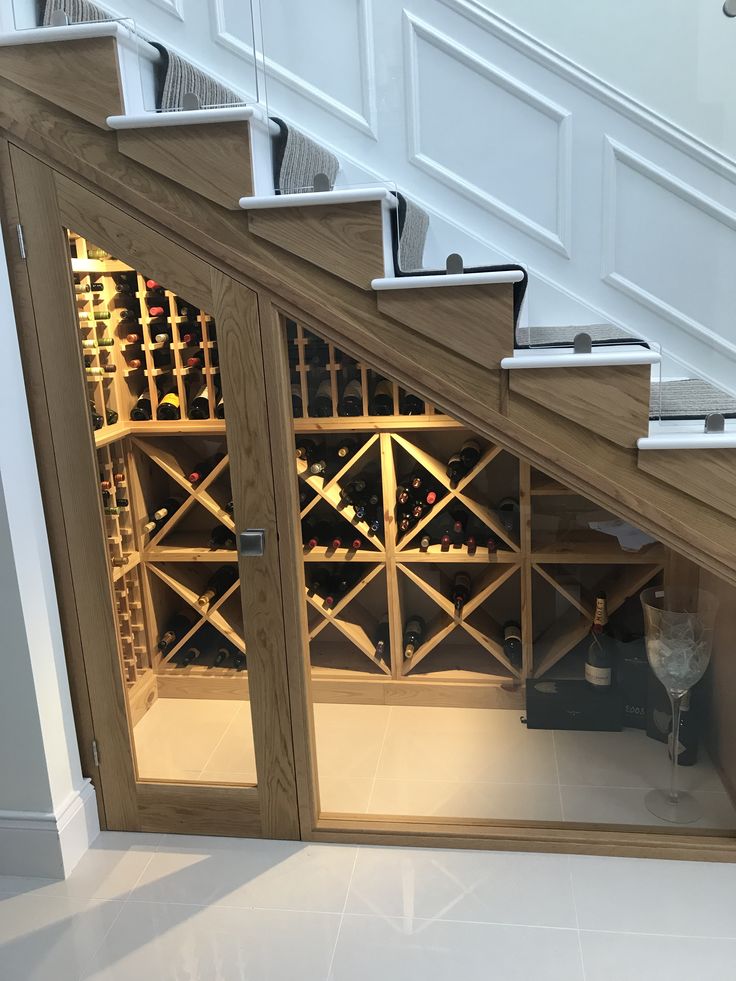 an open wine rack under the stairs