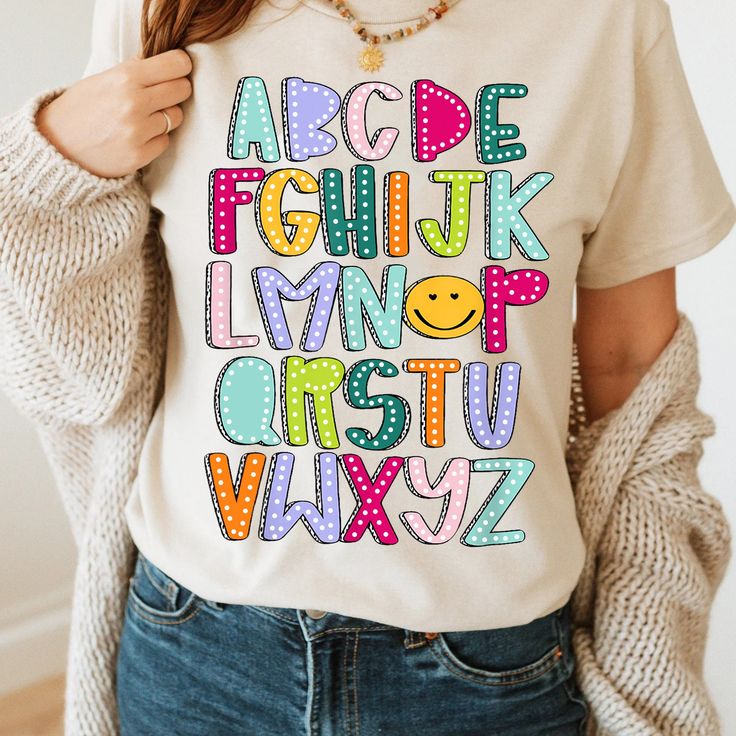 a woman wearing a t - shirt with the words abc, df and l in different colors