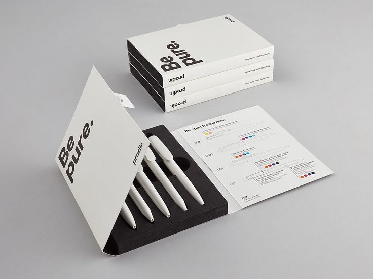 the business card holder is made out of black and white paper, with four pens sticking out of it