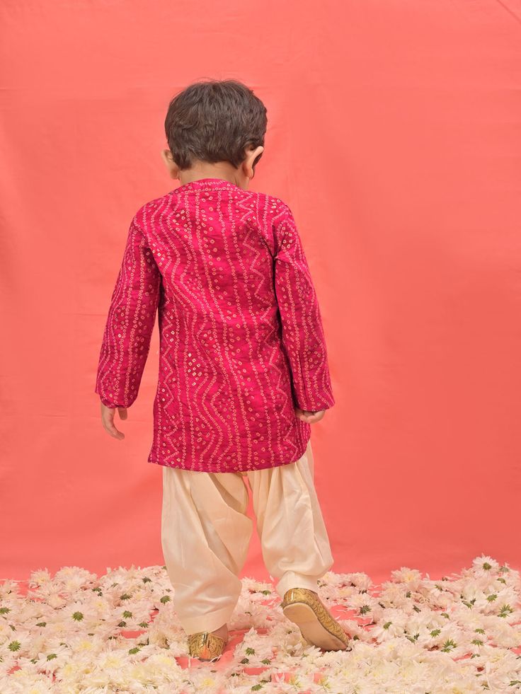 VASTRAMAY SISHU Boys' Pink Bandhni Kurta And Patiala Set Dress your little one in style and tradition with this vibrant pink kurta patiala set. Featuring a beautiful bandhani print, the kurta boasts a comfortable relaxed fit and a mandarin collar. The set comes complete with cream colored patiala pants for a complete and festive look. Key Features Pink Bandhni Print Mandarin Collar Kurta Relaxed Fit Cream Patiala Pants Elasticated Waistband for Comfort Specifications Material: Kurta - Rayon, Pat Festive Bandhani Print Long Sleeve Sherwani, Pink Bollywood Style Kurta For Festivals, Festive Long Sleeve Sherwani With Bandhani Print, Festive Long Sleeve Bandhani Print Sherwani, Pink Kurta For Festivals With Traditional Drape, Festive Bandhani Print Sherwani For Diwali, Diwali Festive Bandhani Print Sherwani, Traditional Drape Pink Kurta For Festivals, Traditional Pink Sherwani For Festivals